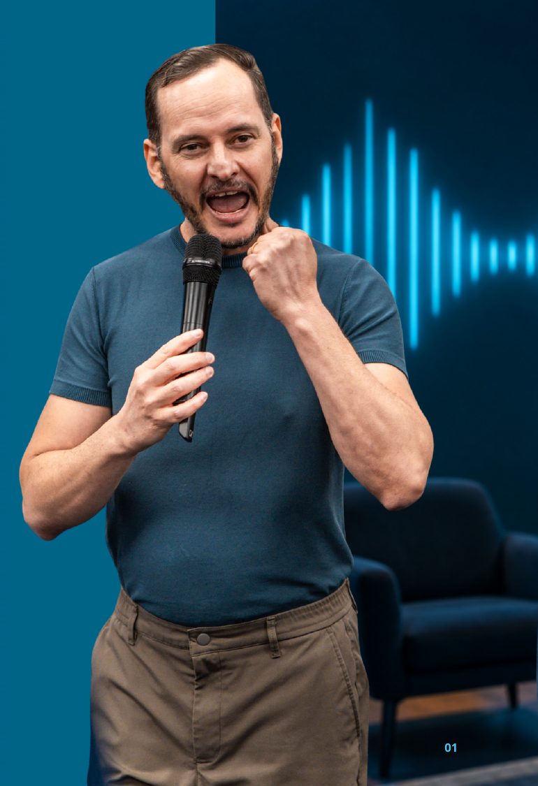 Fabrício Lázaro com microfone, em gesto de energia