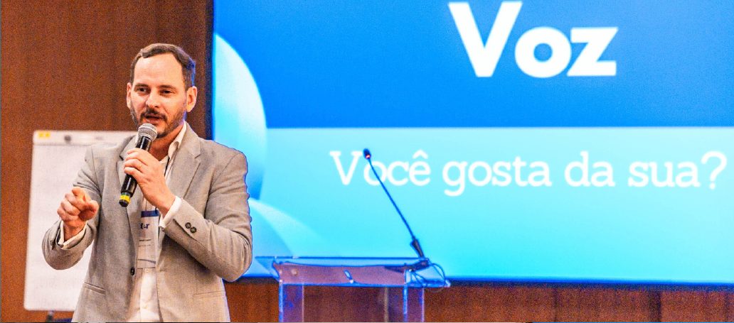 Fabrício Lázaro dando aula no Instituto ITER, diante de um telão com a palavra Voz